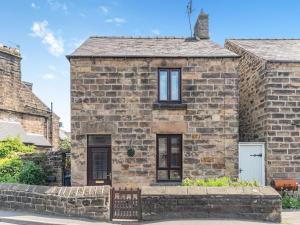 a stone house with a gate in front of it at River Cottage in Two Dales