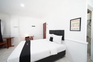 een slaapkamer met een groot wit bed in een kamer bij DS Colive Marina in Semarang
