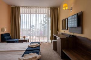 a hotel room with a bed and a large window at Flamingo Beach Hotel in Sunny Beach
