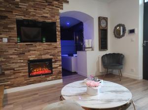 a living room with a fireplace and a tv at Sauna, jacuzzi, terrasse et parking in Rouen