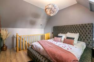a bedroom with a large bed with a brown headboard at Sauna, jacuzzi, terrasse et parking in Rouen