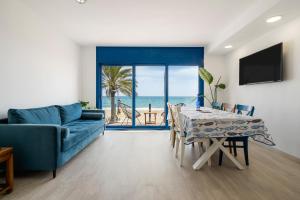 a living room with a blue couch and a table at La Casa del Pescador Calafellmar in Calafell