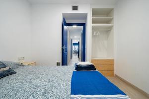 um quarto com uma cama com um cobertor azul em La Casa del Pescador Calafellmar em Calafell