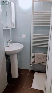 a white bathroom with a sink and a shower at Museo Ostello 