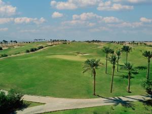 an aerial view of a golf course with palm trees at Jaz Makadi Saraya Resort in Hurghada
