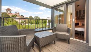 a balcony with chairs and a table and a bedroom at Mediterraneo Luxury Room Esztergom in Esztergom +42 photos