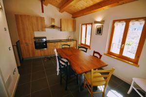 a kitchen and dining room with a wooden table and chairs at Museo Ostello in Ospitale di Cadore