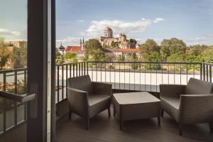 balcone con sedie, tavolo e vista di Mediterraneo Luxury Room Esztergom a Esztergom