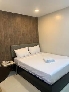 a bed in a small room with a white mattress at Maine City Residences in Manila
