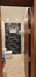 Un baño con inodoro, lavabo y puerta. en Radha Bihari Nikunj Inn, en Vrindāvan