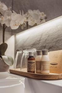 bandeja de madera con 2 botellas de medicina en el mostrador del baño en Mediterraneo Luxury Room Esztergom, en Esztergom
