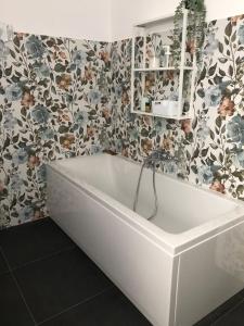 uma banheira na casa de banho com papel de parede floral em Casa Gaiani Villetta in riva al lago vista mozzafiato em Varano Borghi