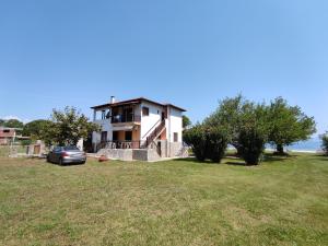 a house with a car parked in a yard at Fyllio's Apartment in Vourvourou