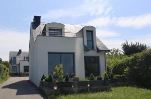 una casa blanca con techo en Maison lumineuse, pour 8, avec vue sur mer en Saint-Gildas-de-Rhuys