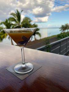 un bicchiere di Martini su un tavolo con vista sull'oceano di Morning Sun Bungalow a Vaitoare