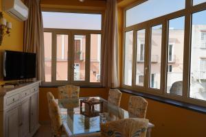 a dining room with a table and chairs and windows at Sunlux Maison in Ischia