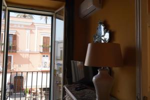 una lampada seduta su un tavolo accanto a una finestra di Sunlux Maison a Ischia