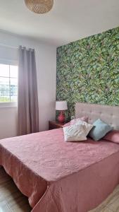 Un dormitorio con una cama rosa con almohadas. en Tropical Apartment - Heated Pool, en Palm-mar