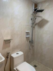 a bathroom with a white toilet and a shower at Maine City Residences in Manila