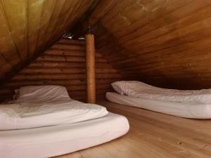SaueにあるVanamõisa Caravan Parkの木製天井のドミトリールームのベッド2台分です。