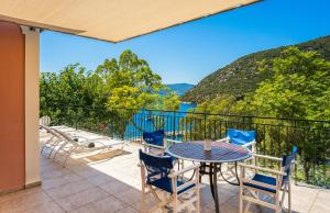 a patio with a table and chairs on a balcony at Lemonia Beach Villa in Stavros