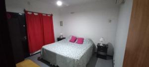 Un dormitorio con una cama con almohadas rosas. en Apartamentos Willy - en Zona Residencial con Estacionamiento en Mendoza