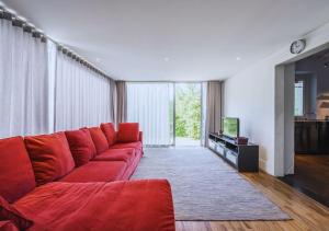 a living room with a red couch and a tv at CountryHouse con Piscina Privata Vicina al Centro in Florence