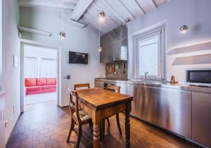 a kitchen with a wooden table and a red couch at CountryHouse con Piscina Privata Vicina al Centro in Florence