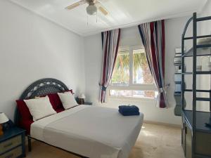 um quarto com uma cama branca e uma janela em Spacious 2-Bedroom Apartment em Orihuela