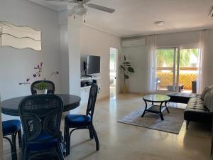 uma sala de estar com uma mesa e cadeiras e um sofá em Spacious 2-Bedroom Apartment em Orihuela