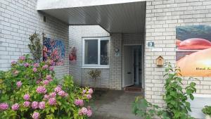 een gebouw met een deur en bloemen ervoor bij B&B de Koepeltjes in Zoetermeer