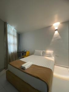 um quarto com uma cama com uma luz na parede em Hotel Lavender Inn em Malaca