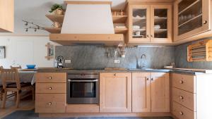 La cuisine est équipée de placards en bois et d'un four avec plaques de cuisson. dans l'établissement Italianway - Milano 26, à Bormio