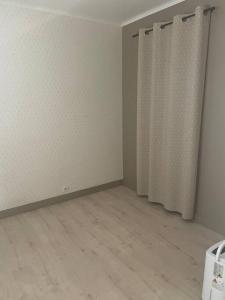 um quarto vazio com uma cortina de chuveiro e um piso em Maison en location em Le Mans