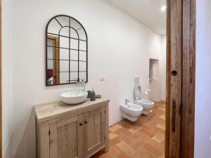 ein Badezimmer mit einem Waschbecken, einem WC und einem Spiegel in der Unterkunft Dilà Assisi Rooms in Assisi