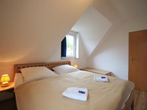 1 dormitorio con 1 cama con 2 toallas en Am Deich 39 en Zingst