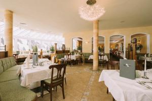 un restaurante con mesas y sillas y una lámpara de araña en Hotel Montana, en Obertauern