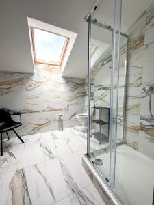 uma casa de banho com uma cabina de duche em vidro e um WC. em MILIA wine & event resort em Dunajský Klátov