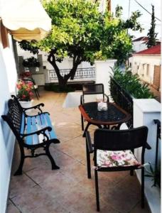 patio z 2 krzesłami, stołem i krzesłami w obiekcie Loula's House w mieście Spetses