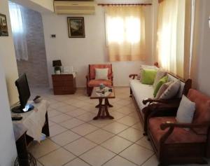 Loula's House في سبيتسيس: غرفة معيشة مع أريكة وتلفزيون