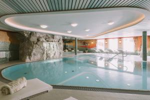 ein großer Pool mit großer Badewanne in einem Gebäude in der Unterkunft Hotel Montana in Obertauern