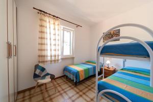 a bedroom with two bunk beds and a chair at Villa Cecilia - Appartamenti in Procchio