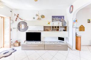 - un salon avec une télévision et un canapé dans l'établissement Casa Luna, à Torre Suda