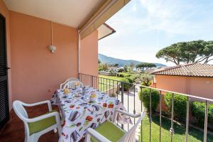 einen Tisch und Stühle auf dem Balkon eines Hauses in der Unterkunft Villa Cecilia - Appartamenti in Procchio
