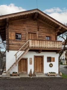 a wooden house with a balcony on top of it at Appartement Am Hof Untertann in Kirchberg in Tirol