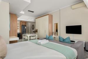 um quarto com uma grande cama branca com almofadas azuis em Crystal Towers 212 em Cidade do Cabo