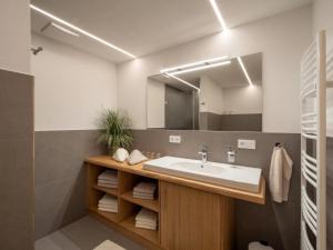 a bathroom with a sink and a mirror at Appartement Am Hof Untertann in Kirchberg in Tirol