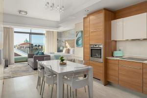 Cape Town的住宿－Crystal Towers 212，厨房以及带白色桌椅的起居室。