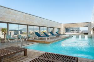 a pool with chairs and tables on a building at Crystal Towers 212 in Cape Town