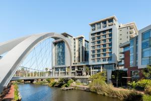 a bridge over a river in front of buildings at Crystal Towers 212 in Cape Town